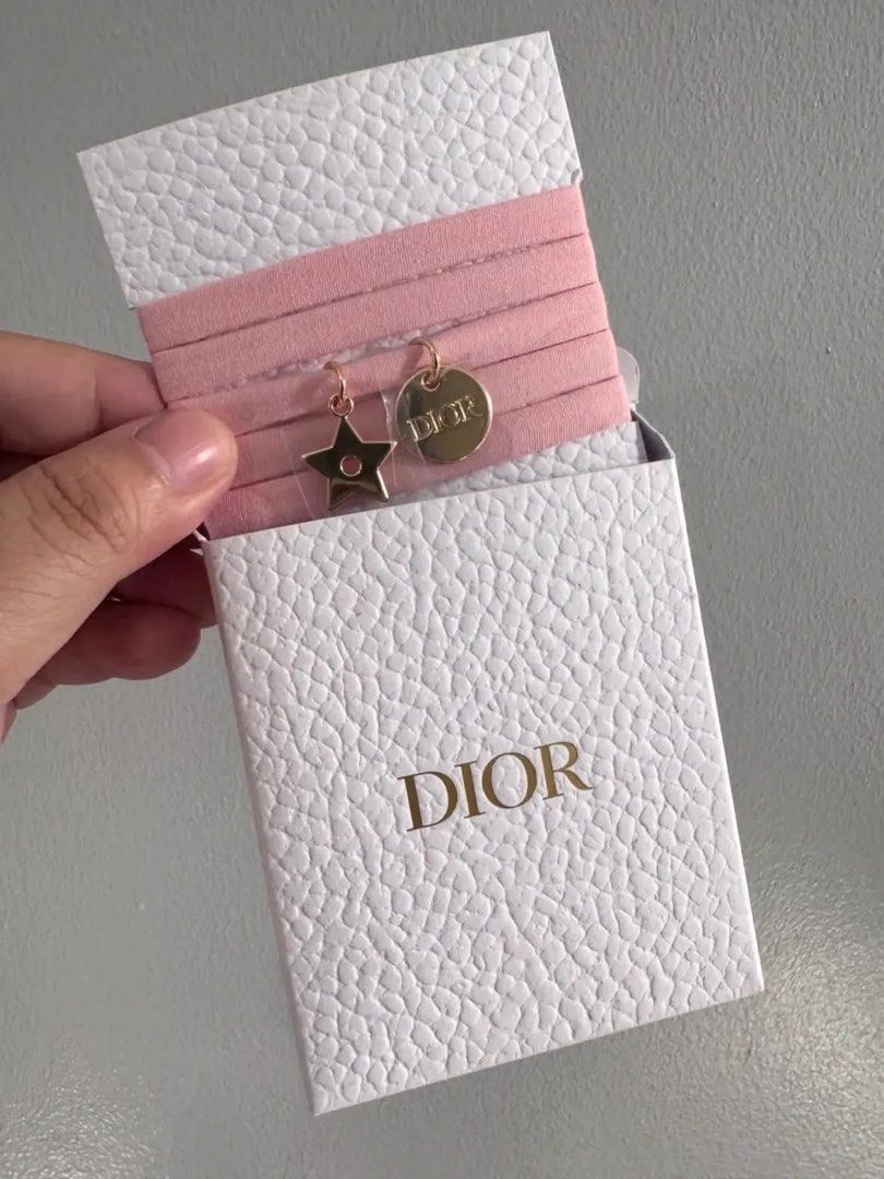 Dior Pink Wrap Around bracwlet Set with Charms (Category: Hair Accessories) located in Mandaluyong City. Submitted by closetshoponline (Listing ID 1468714922, Image 1). Description: - Set of pink wrap around bracelet with rose gold charms - Features a star charm and a round Dior-stamped charm - Unused condition, still attached to original display band - Comes in a white textured box with a matching card - Perfect for everyday use or as a cute gif