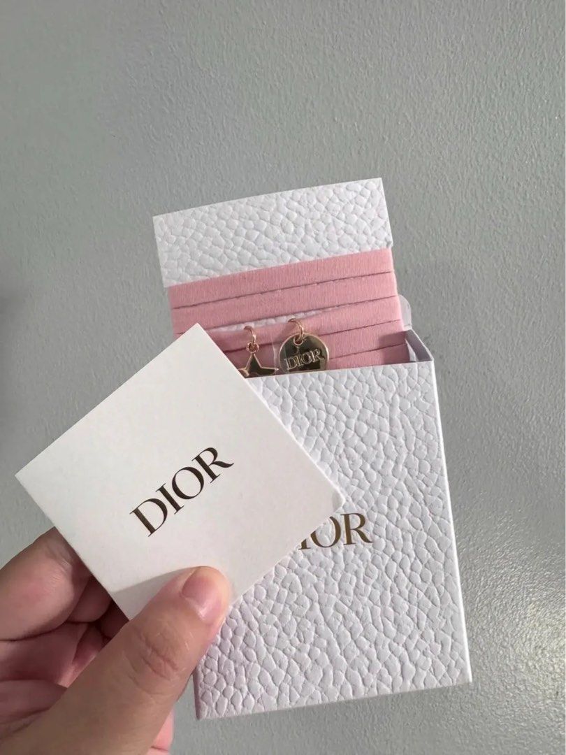 Dior Pink Wrap Around bracwlet Set with Charms (Category: Hair Accessories) located in Mandaluyong City. Submitted by closetshoponline (Listing ID 1468714922, Image 2). Description: - Set of pink wrap around bracelet with rose gold charms - Features a star charm and a round Dior-stamped charm - Unused condition, still attached to original display band - Comes in a white textured box with a matching card - Perfect for everyday use or as a cute gif