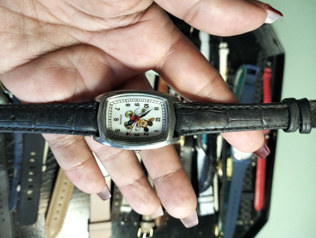 Disney Mickey Mouse Wristwatch with Black Leather Strap (Category: Women's Watches) located in General Mariano Alvarez. Submitted by ma.miafajardo1219 (Listing ID 1468925147, Image 1). Description: - Brand: Disney (Mickey Mouse) - Dial: White rectangular with classic black numbers - Case: Silver-toned with polished metal back (minor hairline scratches) - Strap: Textured black leather with traditional buckle closure - Style: Casual everyday timepi