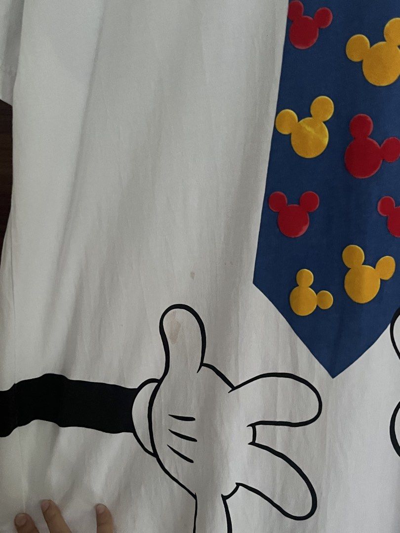 Disneyland Mickey Mouse Shirt (Category: Tshirts & Polo Shirts ) located in Manila. Submitted by thrifted.shits (Listing ID 1468766621, Image 3). Description: - Item: Hong Kong Disneyland Mickey Mouse Graphic Tee - Color: White - Size: L (Tag attached) - Design: Front features Mickey peeking behind a blue tie with red/yellow silhouettes; back features a large Mickey silhouette in striped shirt and blue shorts - Details: Short sleeves, crew neck -