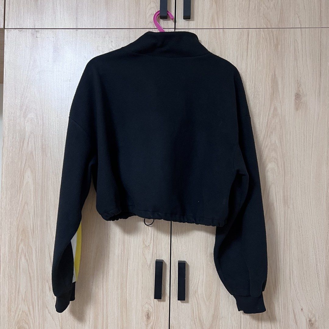Divided by H&M Black Crop Fleece Pullover (Category: Coats, Jackets and Outerwear) located in Manila. Submitted by neovrz (Listing ID 1468751599, Image 2). Description: - Brand/Model: Divided by H&M crop sweatshirt - Color: Black with bold yellow and white stripes - Size: L (tag attached) - Material: Soft, warm, and cozy fleece - Features: High collar with ring zipper and adjustable drawstring hem Payment: Gcash/BPI Delivery: J&T, LBC, Lalamove N