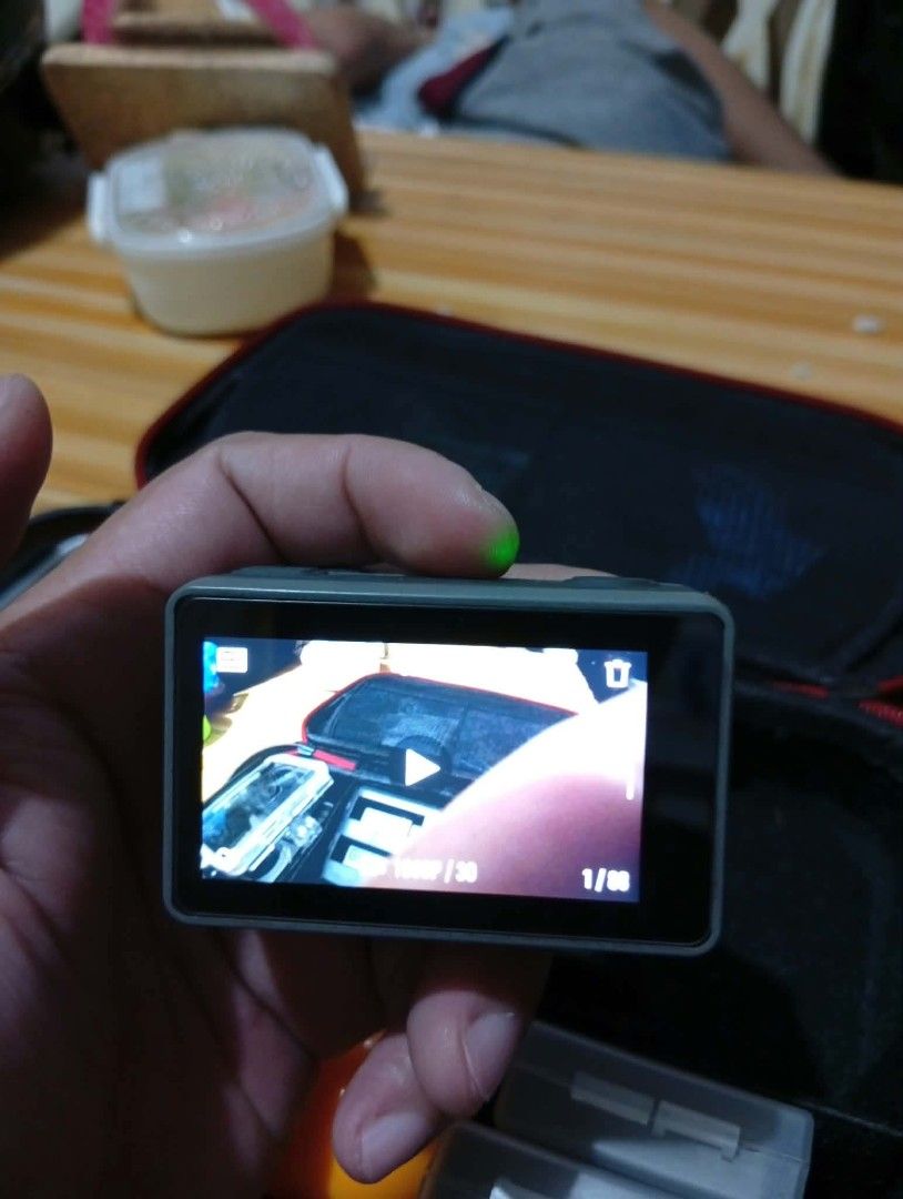 DJI Osmo Action Camera (Category: Cameras) located in Makati City. Submitted by yheenjiro123091 (Listing ID 1468797555, Image 3). Description: - Tested and 100% working DJI Osmo Action camera - Powers on successfully with green LED indicator active - Clear rear touchscreen displaying playback interface smoothly - Perfect compact device for travel, sports, and outdoor adventures - Includes protective carrying case and handy battery storage boxes -