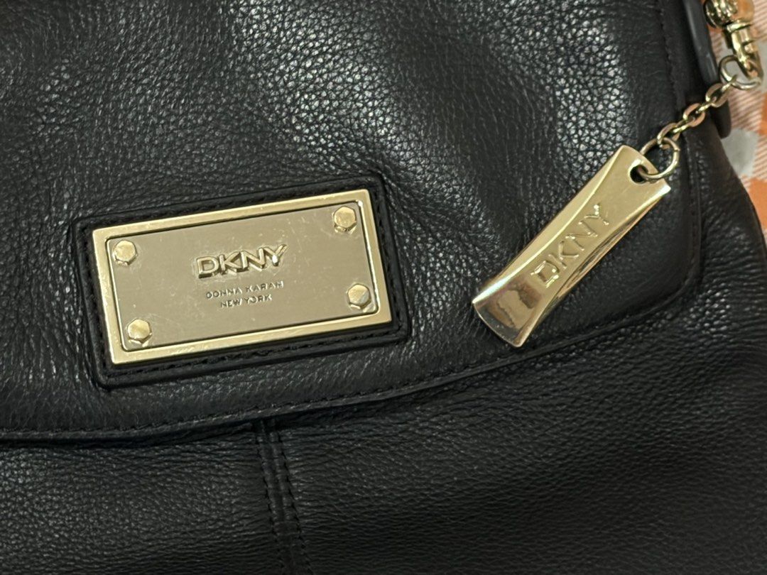 DKNY Donna Karan Purse (Category: Luxury Bags & Wallets) located in Manila. Submitted by jdace (Listing ID 1468845721, Image 2). Description: - 100% genuine black leather with a clean pebble grain texture - Elegant gold-tone hardware including a front rectangular logo plaque and side metal charm - Structured everyday design with stylish vertical seam detailing - Comfortable, adjustable thin black leather shoulder strap - Trusted seller with great