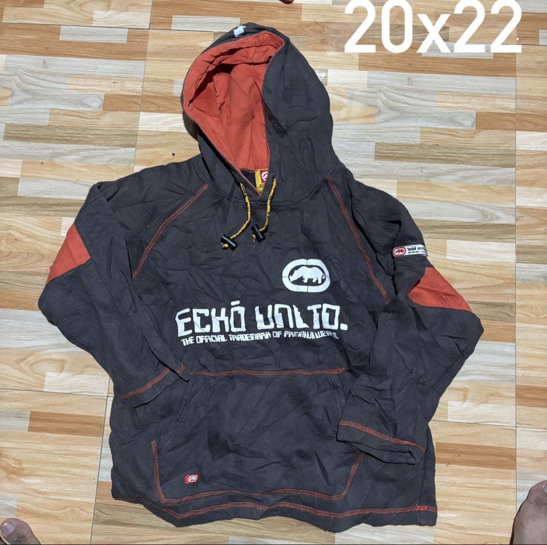 Ecko Unltd. Hooded Sweatshirt Grey Orange Size 140 (Category: Coats, Jackets and Outerwear) located in Tubigon. Submitted by wawiesunbe75372 (Listing ID 1468843365, Image 1). Description: - Brand: Ecko Unltd. - Size: 140 (Kids/Youth) - Color: Grey with vibrant orange accents and yellow drawstrings - Design: Large logo graphics on the chest and back hem - Features: Kangaroo pocket, contrast orange stitching throughout, and ribbed cuffs/hem - Condi