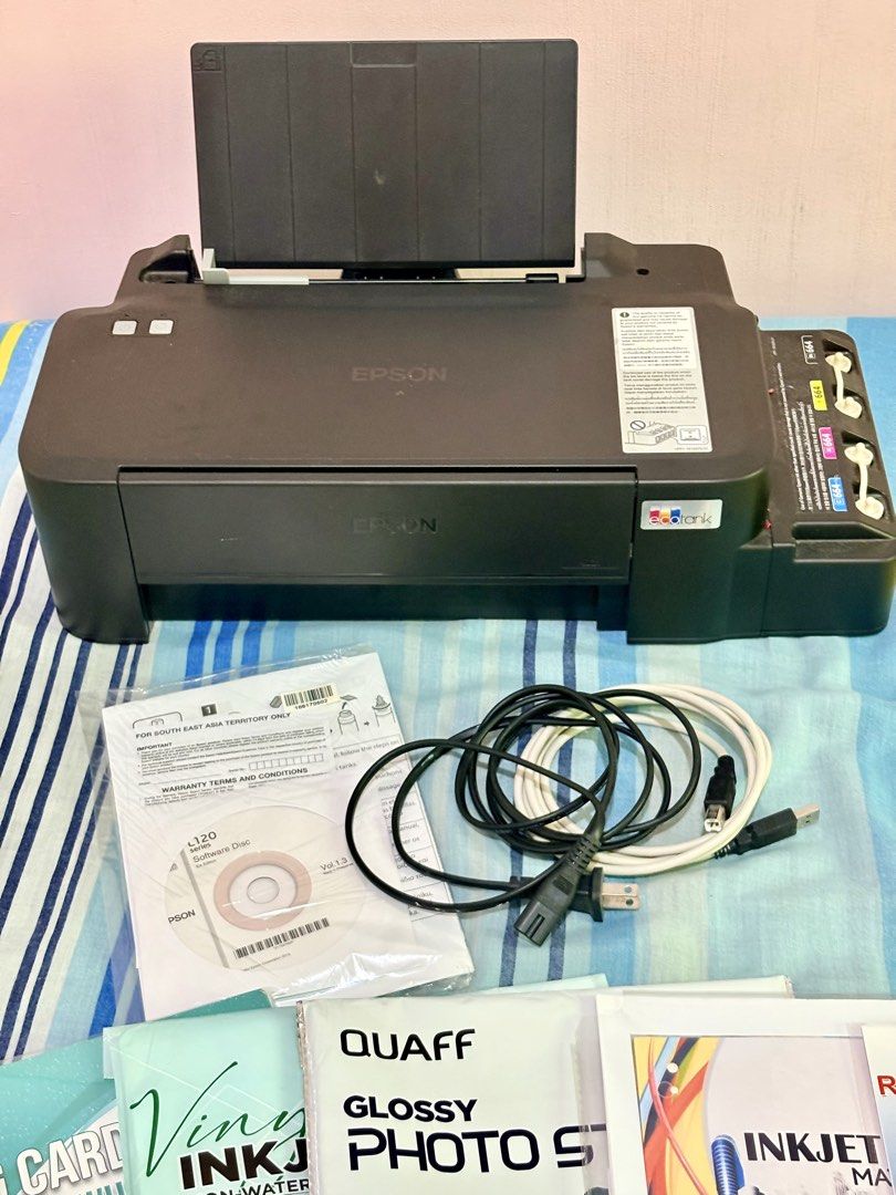 Epson L121 Printer with Paper bundles (Category: Printers, Scanners & Copiers) located in Lipa City. Submitted by heyimdg (Listing ID 1468717004, Image 2). Description: PRINTER SET with ~1.1k worth of materials & ink Inclusions: Epson Ecotank L121 (w/ full ink) Power cable CD Driver, Setup Guide & Utilities Remaining ink bottles A4 Photo Paper 115gsm A4 Photo Paper 230gsm RC Woven 5R Photo Paper Glossy Photo Sticker A4 Inkjet Matte Paper 108gsm V