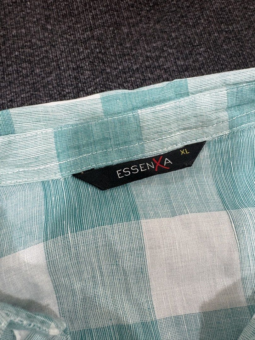 Essenxa Green White Plaid Button Up Shirt XL (Category: Shirts) located in Quezon City. Submitted by fast.closetfinds (Listing ID 1468774792, Image 2). Description: - Brand: Essenxa - Size: XL - Color/Pattern: Green and white check - Design: Long sleeves with metallic snap-button closure - Pockets: Dual chest pockets with button flaps - Fabric: Lightweight and comfortable for casual wear.