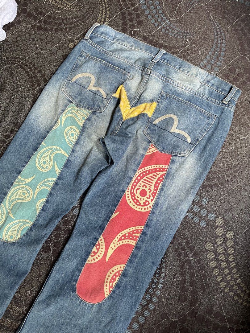 Evisu Denim Jeans Colorful Paisley Patchwork Back Y2K (Category: Jeans) located in Manila. Submitted by chawmichael (Listing ID 1468880593, Image 3). Description: - Style: Straight fit light wash denim jeans - Detailing: Embroidered gull logos on back pockets with yellow V-shaped yoke - Patches: Vibrant teal paisley patch on left leg, red paisley patch on right leg - Closure: Button fly - Finish: Fading on knees and thighs for a worn-in look - Co