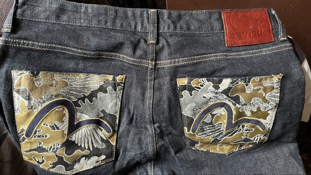 Evisu Slim Fit Camo Pocket Jeans (Category: Jeans) located in Tacloban City. Submitted by rxluminoque (Listing ID 1468832759, Image 2). Description: Size 34x40 - Brand: Evisu - Fit: Slim fit - Color: Clean dark indigo wash - Details: Camouflage back pockets with classic gull embroidery - Hardware: Branded metal buttons and leather back patch - Interior: Stamped typography graphics on pocket lining - Condition: Excellent .