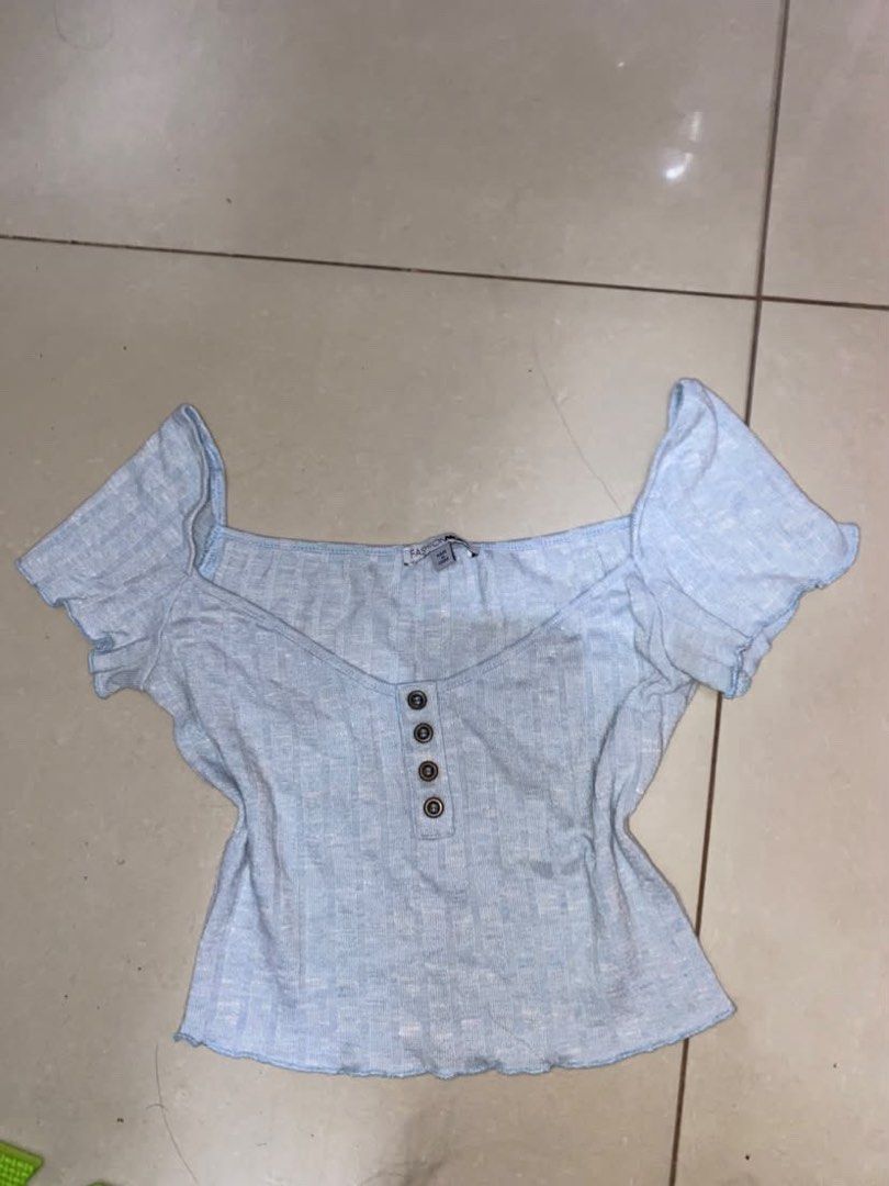 Fashion Nova Light Blue Button Ribbed Crop Top (Category: Sleeveless) located in Manila. Submitted by pinanicolelada (Listing ID 1468866905, Image 1). Description: - Brand: Fashion Nova - Color: Light blue - Style: Ribbed crop top with square neckline and short sleeves - Details: Four dark brown front buttons and trendy lettuce hem on sleeves and hemline - Material: Stretchy, comfortable fabric - Condition: Great casual piece for everyday styling