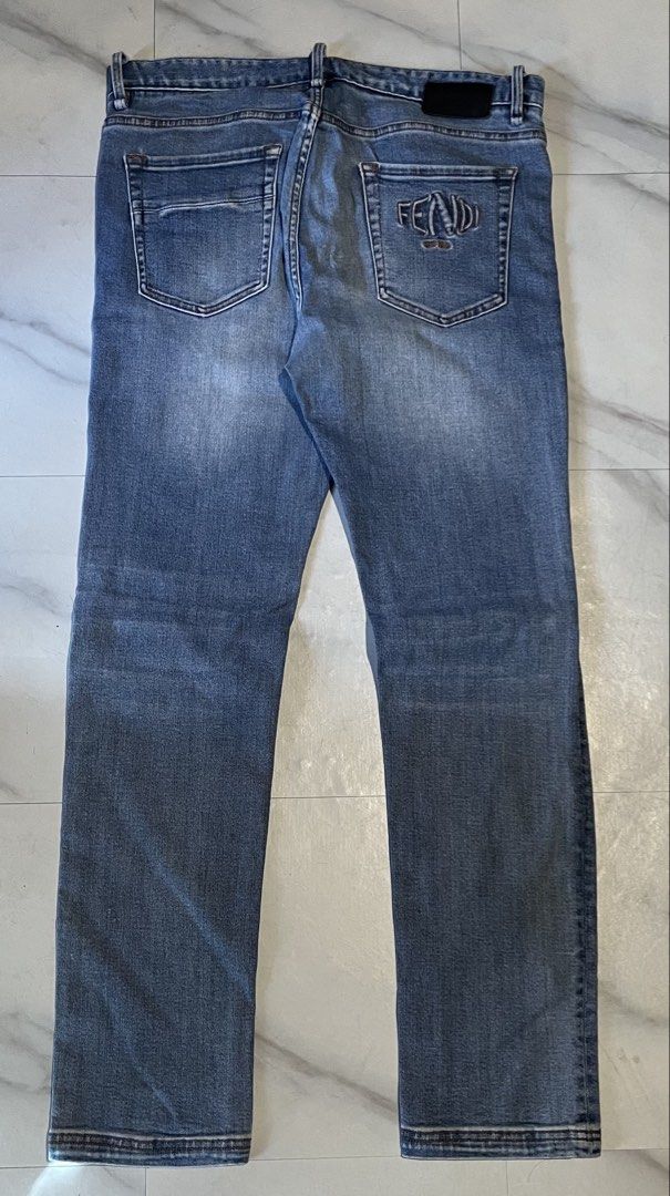 Fendi Roma Blue Denim Jeans (Category: Jeans) located in Cavite. Submitted by christianzuuu (Listing ID 1468766142, Image 1). Description: Fendi denim jeans in mid blue wash. Embroidered Fendi Roma logo on the back pocket. Branded hardware on buttons and leather patch on waistband. Straight leg fit with classic five-pocket styling. Tagged waist 33 and length 34. Measured laying flat: waist 17 inches, length 41 inches, leg opening 9.5 inches..