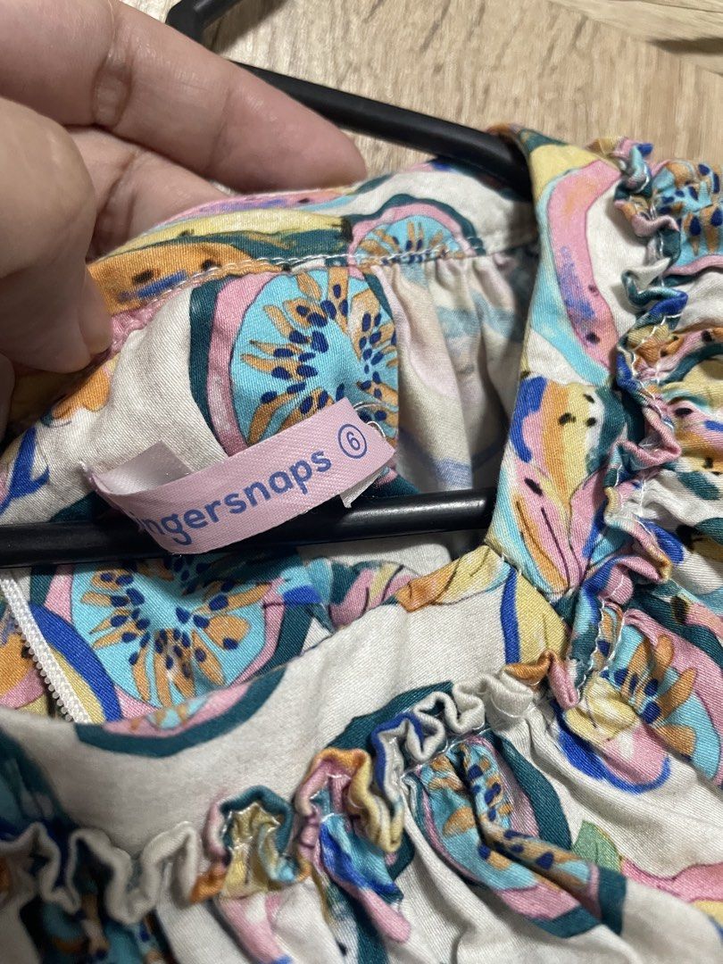fingersnaps Fruit Print Off-Shoulder Romper Size 6 (Category: Babies & Kids Fashion) located in Bulacan. Submitted by PrelovedHub12 (Listing ID 1468881040, Image 2). Description: - Brand: Fingersnaps - Size: 6 - Design: Colorful all-over tropical fruit print on a light background - Neckline: Off-shoulder with chic ruffled collar detail - Sleeves: Short puff sleeves with comfortable elastic cuffs - Fit: Elasticated waistline for a lovely fit and f