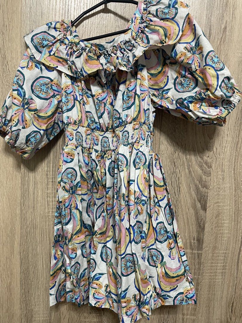 fingersnaps Fruit Print Off-Shoulder Romper Size 6 (Category: Babies & Kids Fashion) located in Bulacan. Submitted by PrelovedHub12 (Listing ID 1468881040, Image 1). Description: - Brand: Fingersnaps - Size: 6 - Design: Colorful all-over tropical fruit print on a light background - Neckline: Off-shoulder with chic ruffled collar detail - Sleeves: Short puff sleeves with comfortable elastic cuffs - Fit: Elasticated waistline for a lovely fit and f