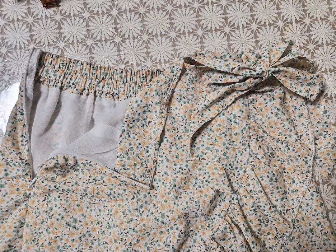 Floral Ruffle Wrap Skirt with Bow Tie (Category: Skirts) located in Manila. Submitted by prelovedbyc.hannah (Listing ID 1468771810, Image 3). Description: - Floral wrap skirt with white base and small yellow/green flowers - Features a sweet side tie ribbon and trendy ruffled hem - Comfortable fit with an elastic waistband at the back and side zipper - Comes with a white inner lining underneath for extra coverage - Made of light and flowy material