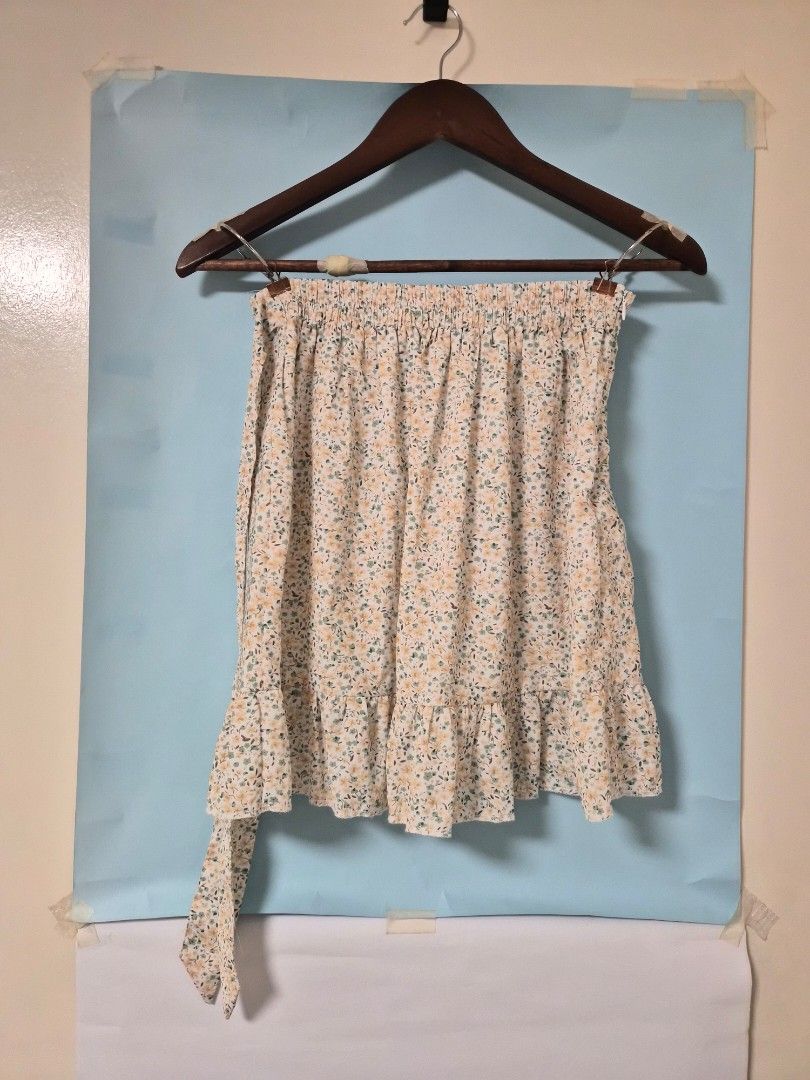 Floral Ruffle Wrap Skirt with Bow Tie (Category: Skirts) located in Manila. Submitted by prelovedbyc.hannah (Listing ID 1468771810, Image 1). Description: - Floral wrap skirt with white base and small yellow/green flowers - Features a sweet side tie ribbon and trendy ruffled hem - Comfortable fit with an elastic waistband at the back and side zipper - Comes with a white inner lining underneath for extra coverage - Made of light and flowy material