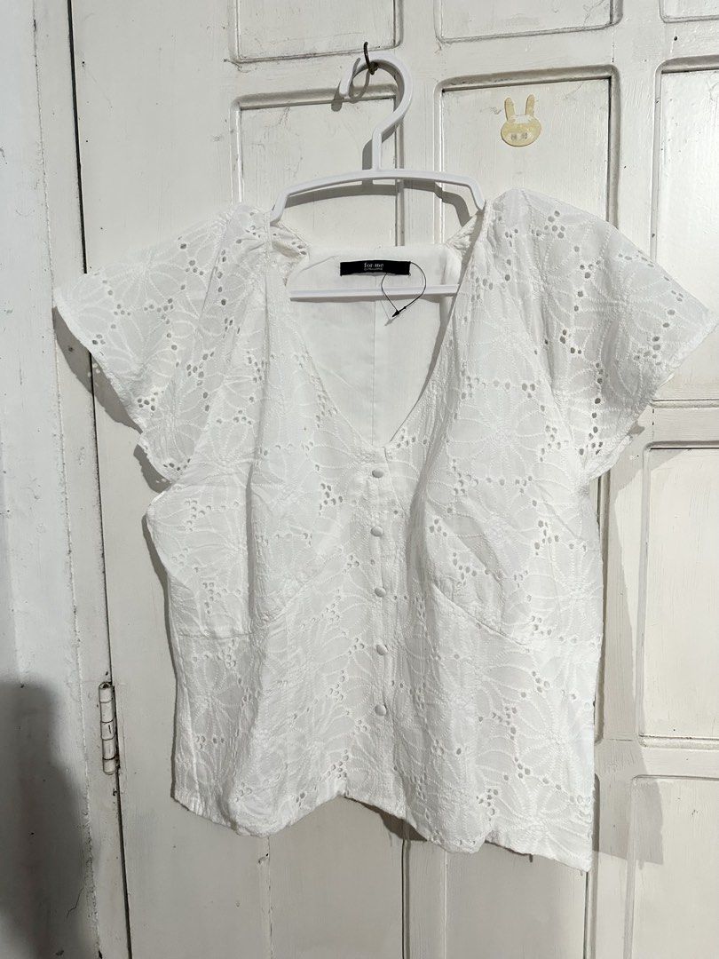 For Me White Eyelet Button-Down Blouse (Category: Blouses) located in Naga. Submitted by leelovella64554 (Listing ID 1468777516, Image 1). Description: - Brand: For Me - Style: White eyelet blouse with V-neckline and small fabric buttons - Sleeves: Short flutter sleeves - Material: Lightweight cotton with all-over cutout floral patterns - Details: Fully lined body, convenient side zipper closure - Condition: Clean and ready to wear.