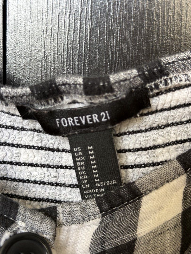 Forever 21 Black and White Gingham Crop Top (Category: Sleeveless) located in Manila. Submitted by caeln (Listing ID 1468762467, Image 3). Description: - Brand: Forever 21 - Size: M - Pattern: Black and white gingham check - Details: Square neckline, puff sleeves, front button closure, and a stretchy smocked back panel - Condition: Worn a few times, washed, and well-kept.