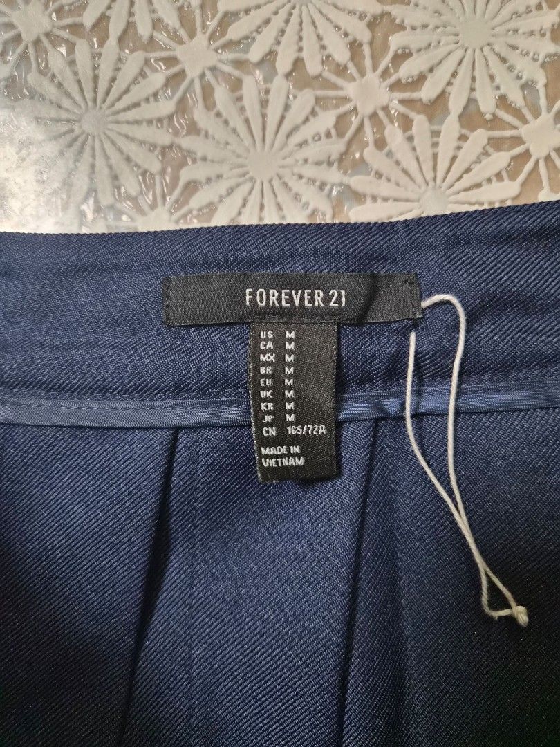Forever 21 Navy Pleated Skirt Size M (Category: Skirts) located in Manila. Submitted by prelovedbyc.hannah (Listing ID 1468779759, Image 3). Description: - Brand: Forever 21 - Size: M (165/72A) - Color: Navy blue with white double stripe accents - Closure: Side zipper and matching waistband button - Details: Textured fabric with a clean interior lining.