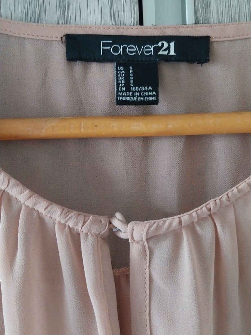 Forever 21 Pink Polka Dot Chiffon Blouse (Category: Blouses) located in Makati City. Submitted by everythingp100 (Listing ID 1468776595, Image 3). Description: - Brand: Forever 21 - Size: Small - Color: Dusty Pink - Material: Lightweight sheer chiffon - Details: Long sleeves with gathered cuffs, keyhole neckline with loop button closure, curved hemline - Accent: Semi-sheer dark upper back panel with a cute polka dot pattern - Condition: Excellent