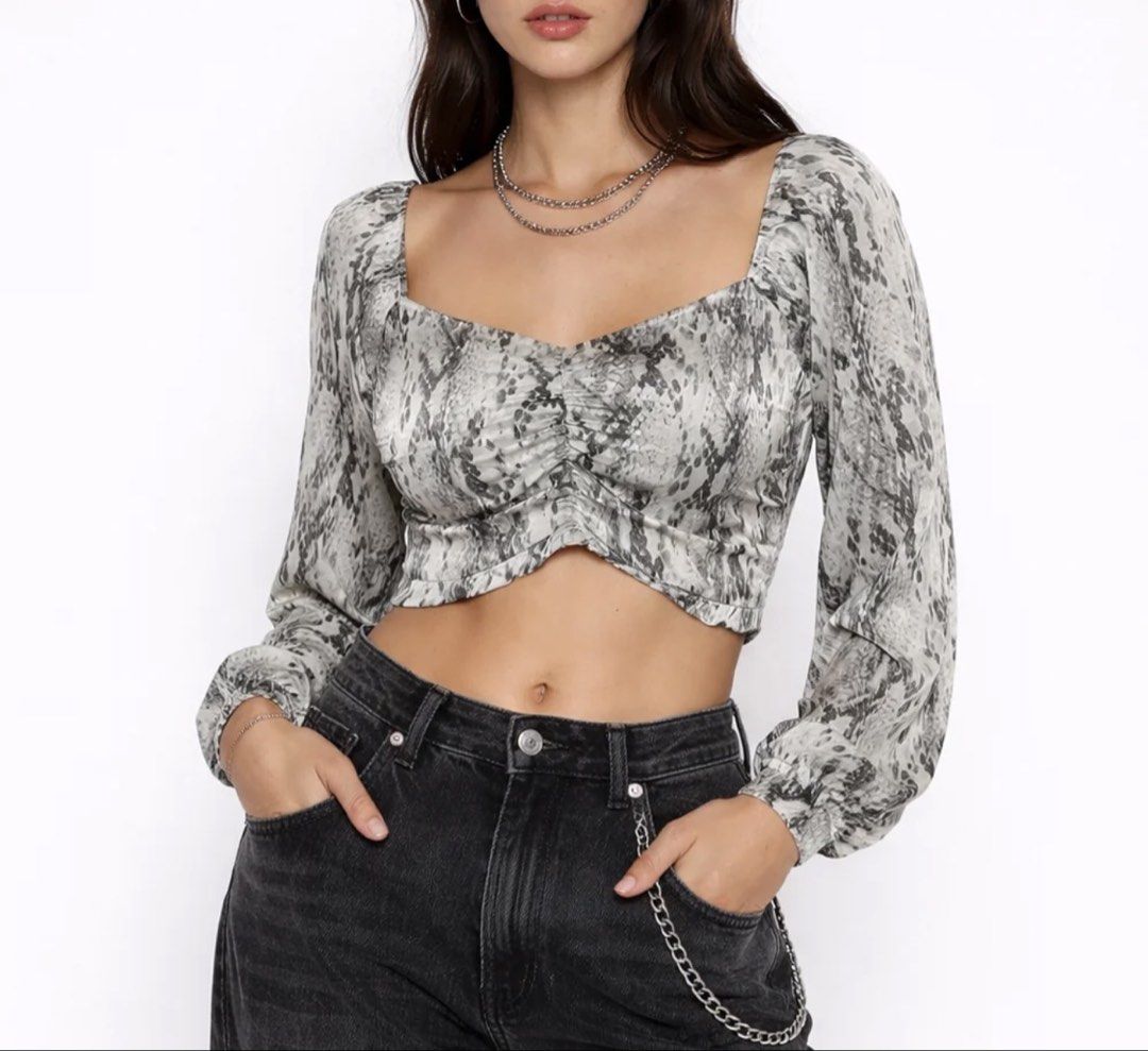 Forever 21 Snake Print Crop Top Size M (Category: Blouses) located in Manila. Submitted by caeln (Listing ID 1468761398, Image 1). Description: - Brand: Forever 21 - Size: M - Pattern: Grey snake print - Design: Square neckline, long sleeves with slight puff, ruched front detail - Fit: Cropped length above the waist - Material: Smooth, lightweight satin-like fabric - Styling: Perfect to pair with high-waisted denim or skirts for a night out.