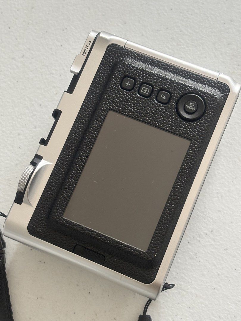 Fujifilm Instax Mini Evo Hybrid Instant Camera (Category: Cameras) located in Dasmarinas. Submitted by bykarla (Listing ID 1468733935, Image 3). Description: - Model: Fujifilm Instax Mini Evo (Silver & Black) - Condition: Clean body, minimal signs of handling, fully functional - Features: Hybrid digital & instant print, creative lens/film effects via dials, rear LCD screen with manual print lever - Inclusions: Black neck strap - Status: Ready for