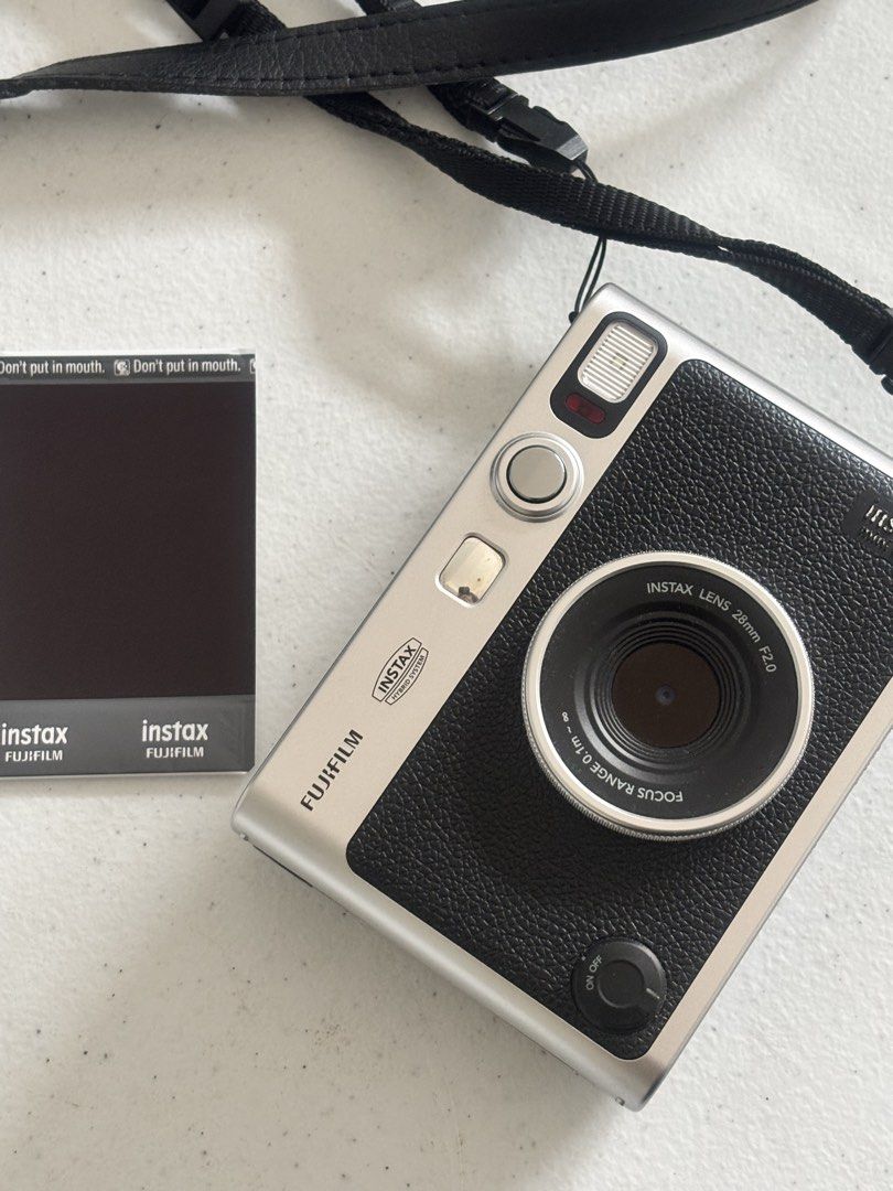 Fujifilm Instax Mini Evo Hybrid Instant Camera (Category: Cameras) located in Dasmarinas. Submitted by bykarla (Listing ID 1468733935, Image 1). Description: - Model: Fujifilm Instax Mini Evo (Silver & Black) - Condition: Clean body, minimal signs of handling, fully functional - Features: Hybrid digital & instant print, creative lens/film effects via dials, rear LCD screen with manual print lever - Inclusions: Black neck strap - Status: Ready for