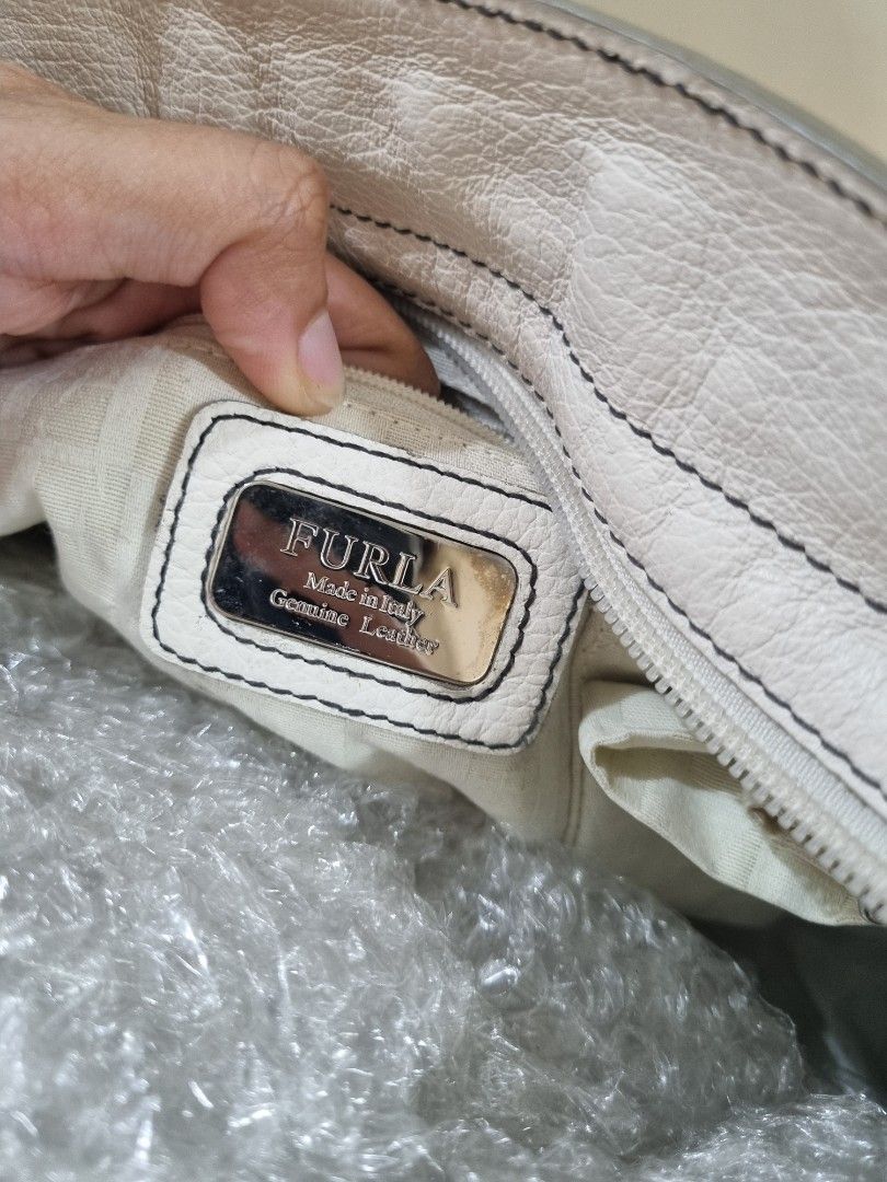 Furla White Leather Tote Bag (Category: Luxury Bags & Wallets) located in Quezon City. Submitted by gabdclutz (Listing ID 1468840438, Image 2). Description: - Brand: Furla - Material: Genuine white leather (Made in Italy) - Hardware: Silver-tone - Closure: Top zip - Straps: Dual shoulder straps - Interior: Clean logo-patterned lining with pockets - Condition: Excellent, spacious for everyday use - Shipping: Angkas padala / grab express direct pay
