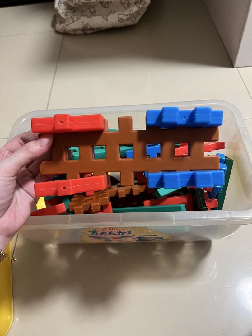 Gakken Tonkachi Blocks Set with Storage Box (Category: Lego & Building Sets) located in Quezon City. Submitted by prelovedbykhy (Listing ID 1468904593, Image 2). Description: STILL GOOD CONDITION - Authentic Japanese Gakken construction blocks set - Comes in a plastic storage container with a yellow lid - Colorful interlocking pieces in blue, red, brown, green, and yellow - Includes wheels, beams, and various connector shapes for building vehicle