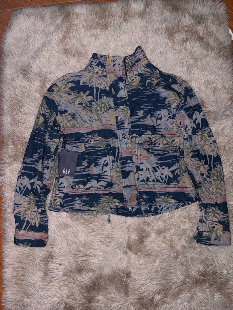 GAP Tropical Palm Print Zip-Up Jacket (Category: Coats, Jackets and Outerwear) located in Pasig City. Submitted by shojiii_zurkiii (Listing ID 1468863311, Image 1). Description: - Brand: GAP - Condition: Like new with tag attached - Color/Design: Blue with all-over tropical palm tree and sailboat print - Features: High mock neck collar, front zipper with snap button placket - Pockets: Two large front patch pockets - Fit & Details: Adjustable draw