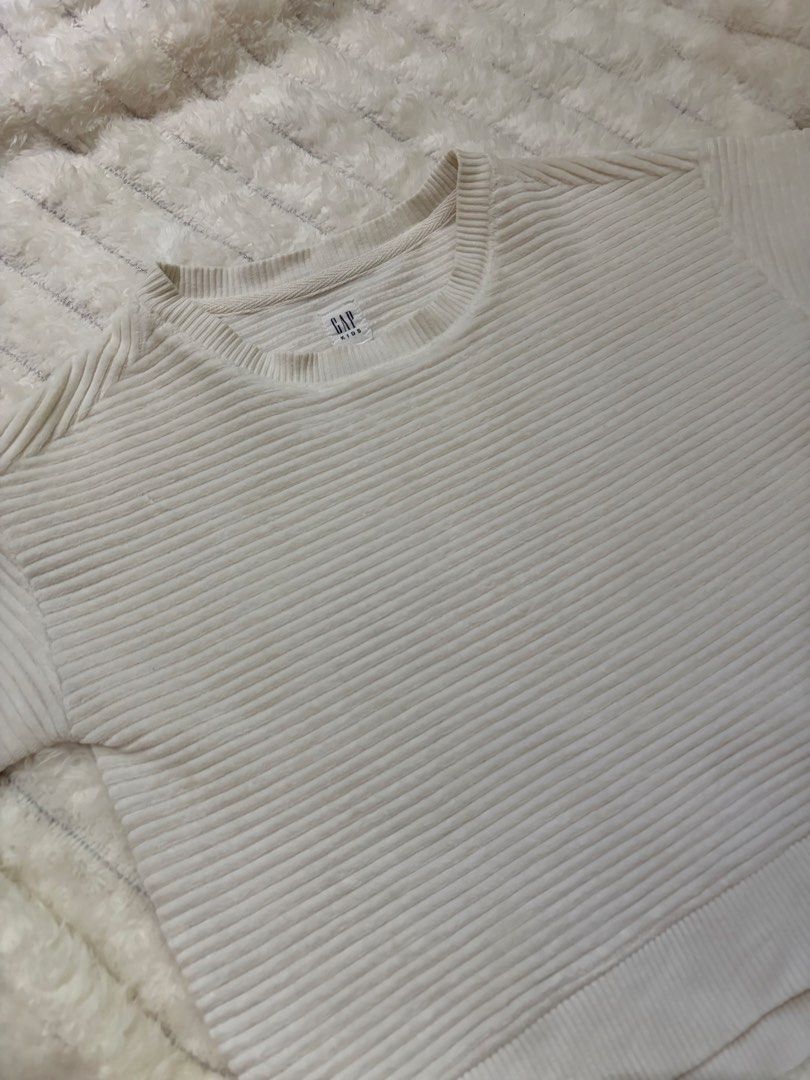 Gap White Ribbed Knit Top (Category: Sleeveless) located in San Mateo. Submitted by heiayafinds (Listing ID 1468833337, Image 1). Description: - Brand: Gap Kids - Color: Classic White - Material: Thick, high-quality ribbed knit fabric - Design: Crew neckline, short sleeves, fitted cropped cut - Condition: Clean and well-kept - Styling tip: Pairs amazingly with high-waisted jeans!.
