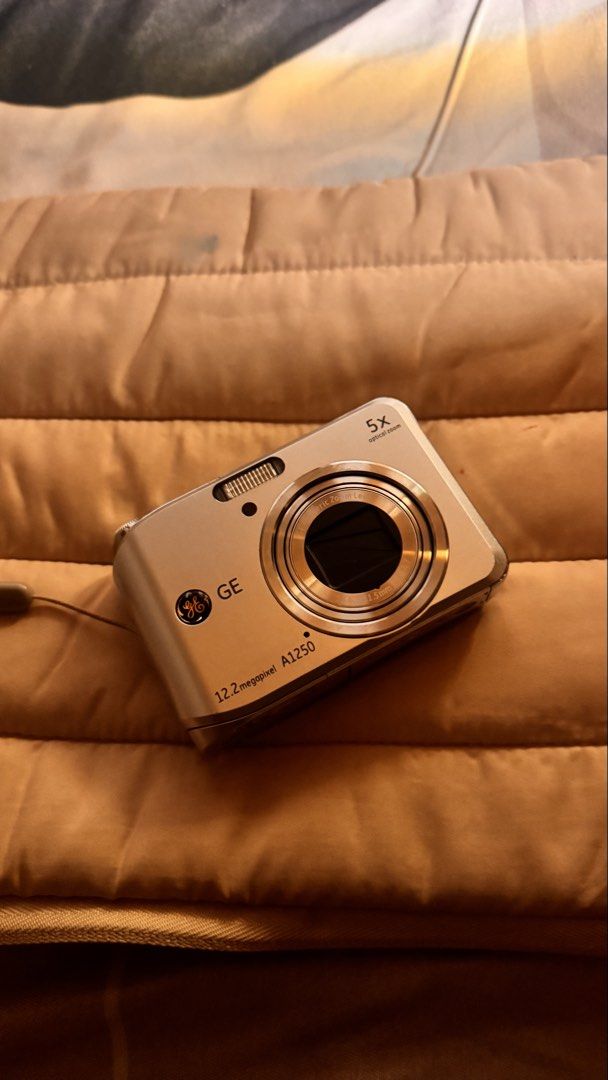 GE A1250 12.2 Megapixel Digital Camera (Category: Cameras) located in Quezon City. Submitted by decluttering.9 (Listing ID 1468922278, Image 1). Description: - Model: GE A1250 Compact Digital Camera (Silver) - Resolution: 12.2 Megapixels with 5x optical zoom lens - Power Source: Uses convenient standard or rechargeable AA batteries - Design: Slim, pocket-friendly body with standard rear screen and button layout - Usability: Simple point-and-shoot