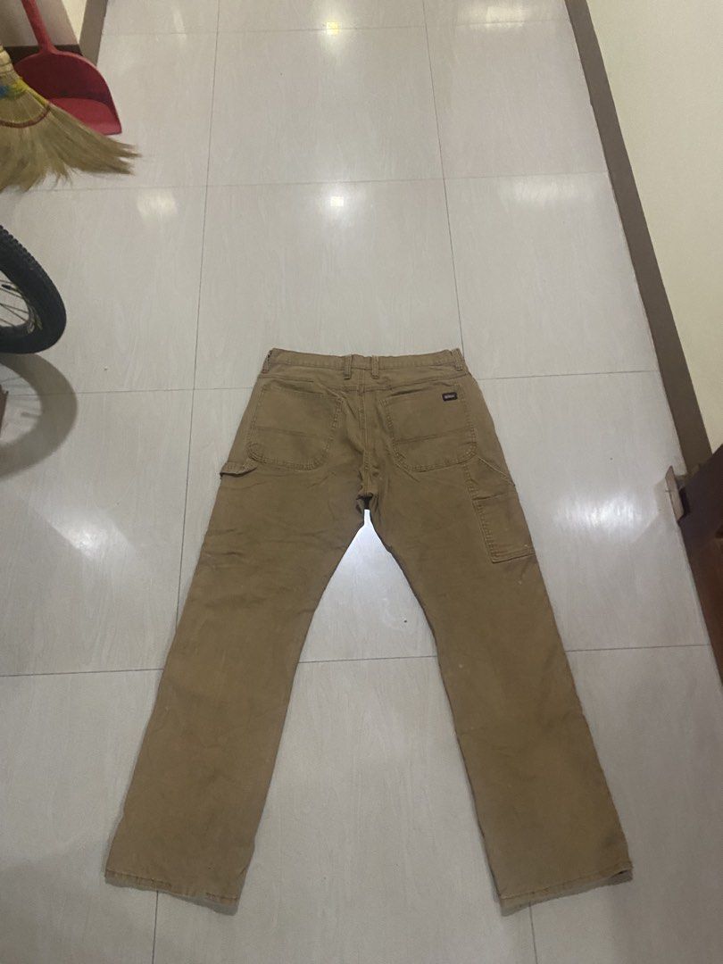 Genuine Dickies Brown Carpenter Pants Size 36x32 (Category: Jeans) located in Vinzons. Submitted by gabrielvic (Listing ID 1468740198, Image 2). Description: - Brand: Genuine Dickies - Style: Classic carpenter utility pants with hammer loop and tool pockets - Size: 36 x 32 - Material: Heavy-duty cotton canvas (Made in Kenya) - Closure: Button waist with zip fly - Condition: Shows natural wear, fading, and some spots throughout from use.