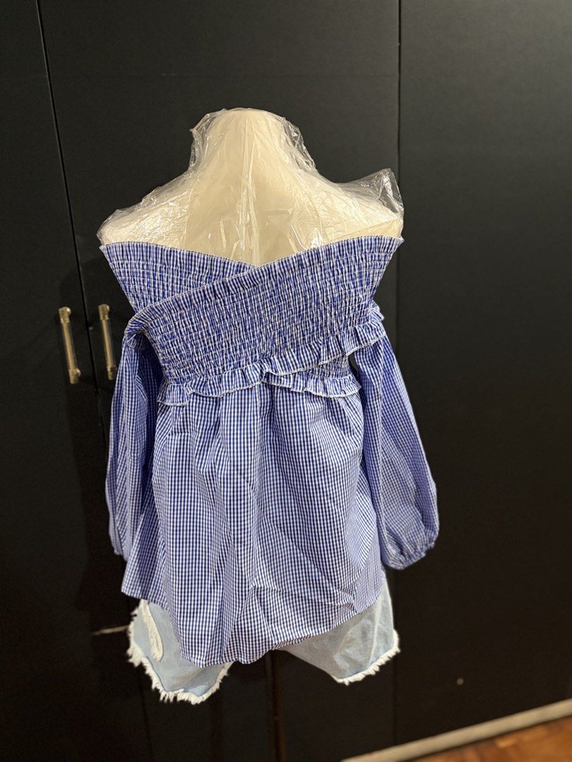 Gingham Off-Shoulder Ruffle Blouse (Category: Blouses) located in Manila. Submitted by everydaymeanseveryday (Listing ID 1468865169, Image 3). Description: - Trendy blue and white gingham print - Off-shoulder neckline with comfortable smocked elastic - Cute ruffled trim and long sleeves with gathered cuffs - Relaxed, easy-to-wear fit - Perfect for pairing with denim shorts or jeans for a weekend look.