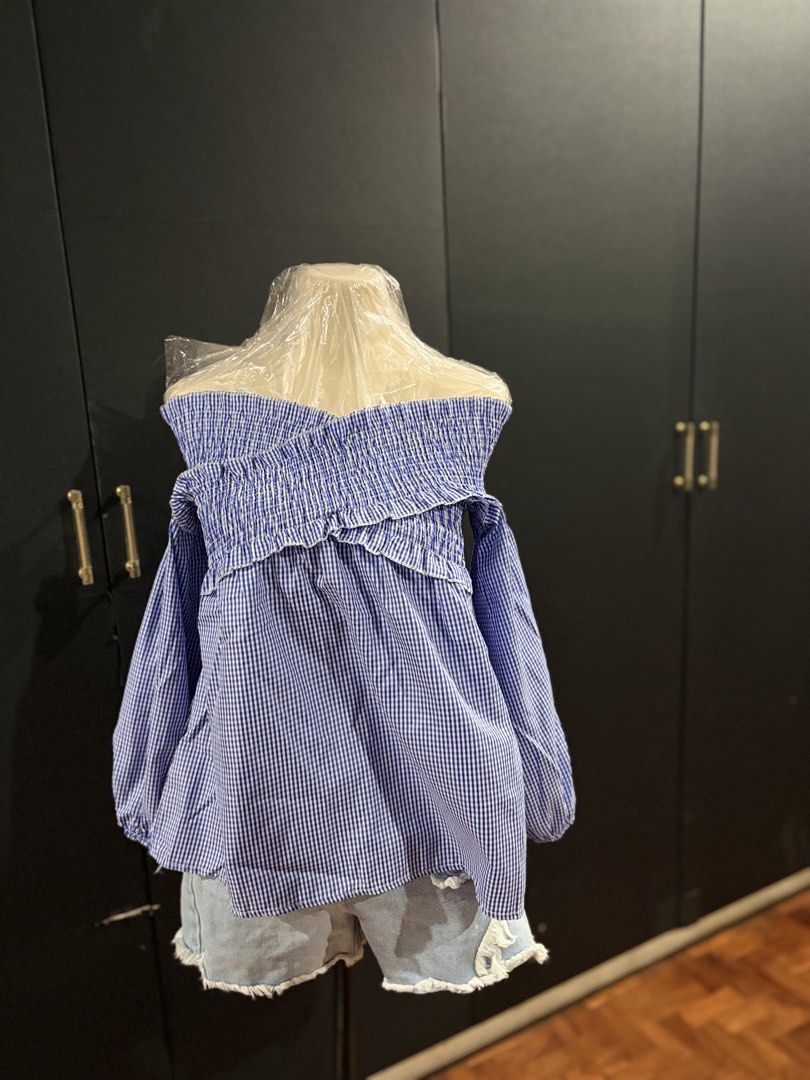 Gingham Off-Shoulder Ruffle Blouse (Category: Blouses) located in Manila. Submitted by everydaymeanseveryday (Listing ID 1468865169, Image 1). Description: - Trendy blue and white gingham print - Off-shoulder neckline with comfortable smocked elastic - Cute ruffled trim and long sleeves with gathered cuffs - Relaxed, easy-to-wear fit - Perfect for pairing with denim shorts or jeans for a weekend look.