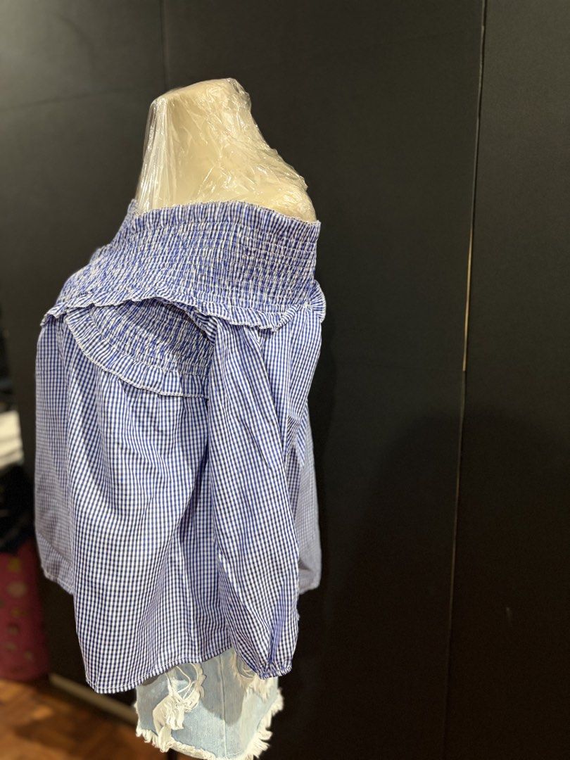 Gingham Off-Shoulder Ruffle Blouse (Category: Blouses) located in Manila. Submitted by everydaymeanseveryday (Listing ID 1468865169, Image 2). Description: - Trendy blue and white gingham print - Off-shoulder neckline with comfortable smocked elastic - Cute ruffled trim and long sleeves with gathered cuffs - Relaxed, easy-to-wear fit - Perfect for pairing with denim shorts or jeans for a weekend look.