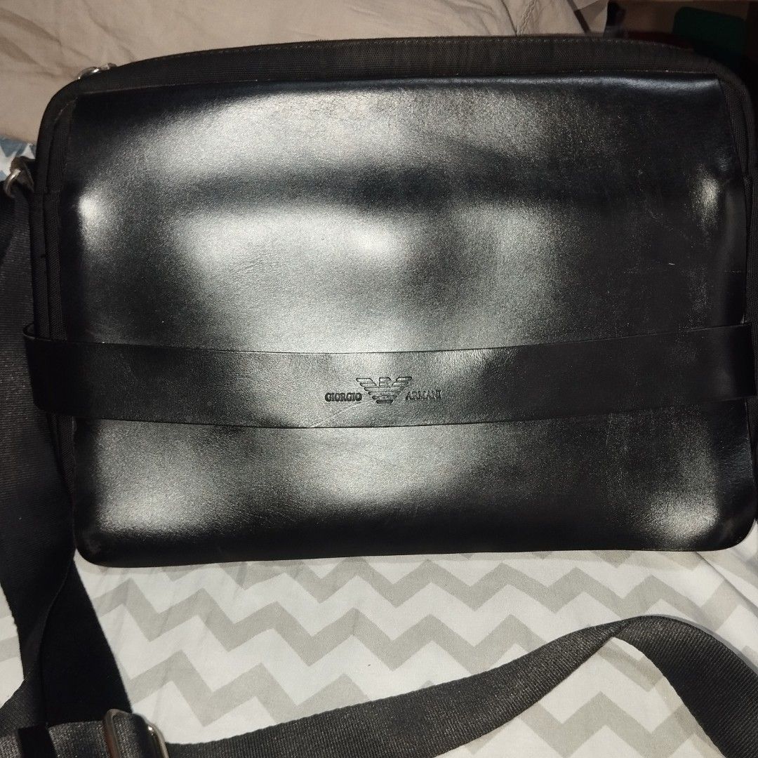 Giorgio Armani Black Messenger Bag (Category: Sling Bags) located in Manila. Submitted by lene48 (Listing ID 1468836289, Image 2). Description: - Brand: Giorgio Armani - Material: Premium smooth leather and durable fabric - Closure: Secure main zip closure with front flap - Interior: Includes zip pocket, internal organiser slots, and branded lining - Exterior: Adjustable strap with metallic hardware, branding badge, and debossed logo strap - Cond