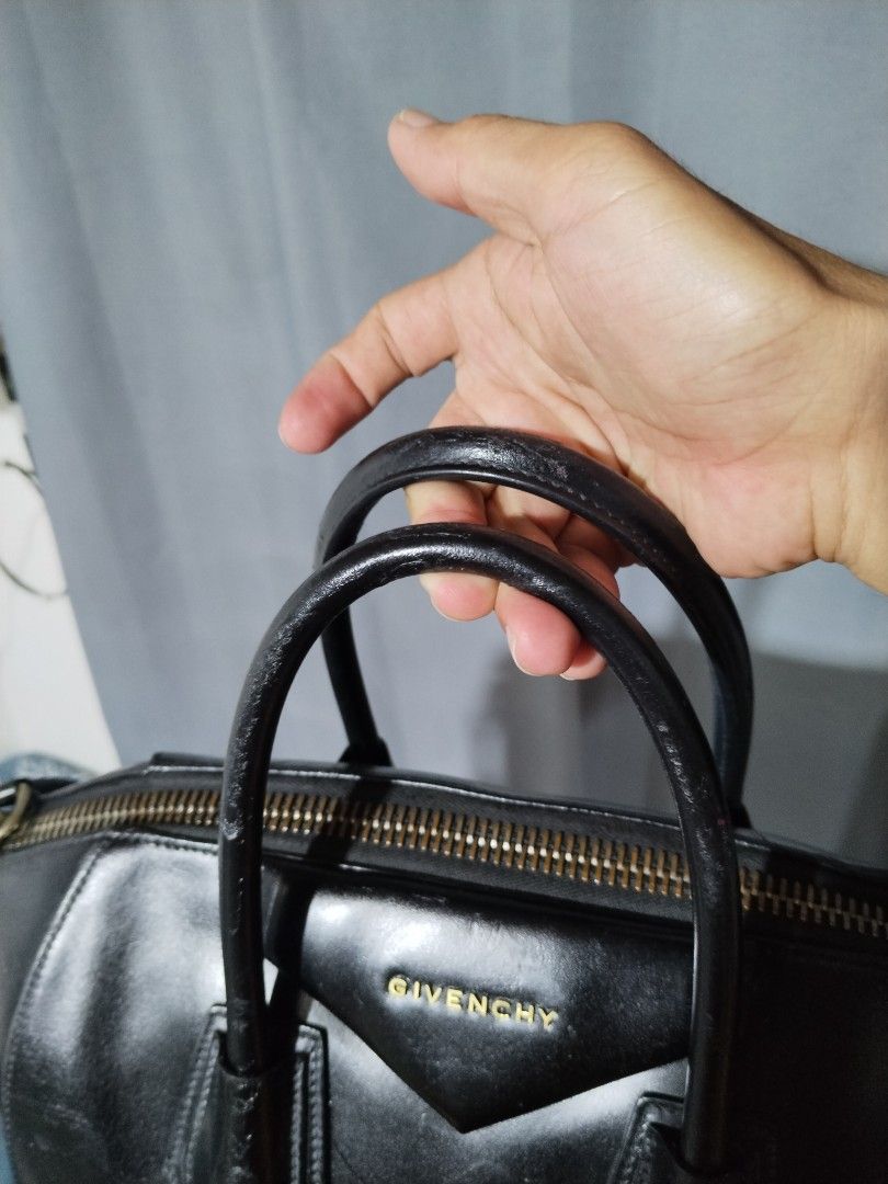 Givenchy Antigona Black Leather Handbag with Strap (Category: Luxury Bags & Wallets) located in Pasig City. Submitted by loveforlux_2025 (Listing ID 1468717434, Image 3). Description: - Brand: Givenchy Antigona - Material: Black leather with gold hardware - Features: Double top handles, removable shoulder strap, and gold logo lettering - Closure: Smooth zip-top closure - Condition: Shows minor scuffs, a small indentation near the base, and slight