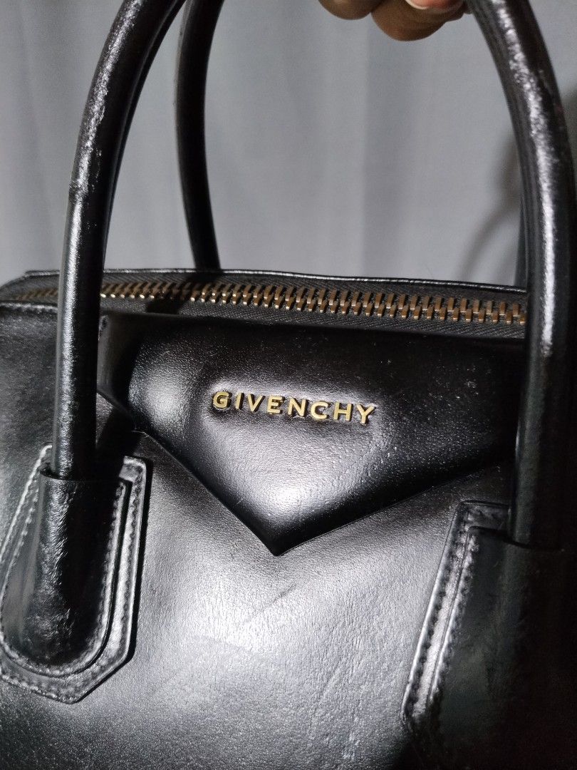 Givenchy Antigona Black Leather Handbag with Strap (Category: Luxury Bags & Wallets) located in Pasig City. Submitted by loveforlux_2025 (Listing ID 1468717434, Image 2). Description: - Brand: Givenchy Antigona - Material: Black leather with gold hardware - Features: Double top handles, removable shoulder strap, and gold logo lettering - Closure: Smooth zip-top closure - Condition: Shows minor scuffs, a small indentation near the base, and slight