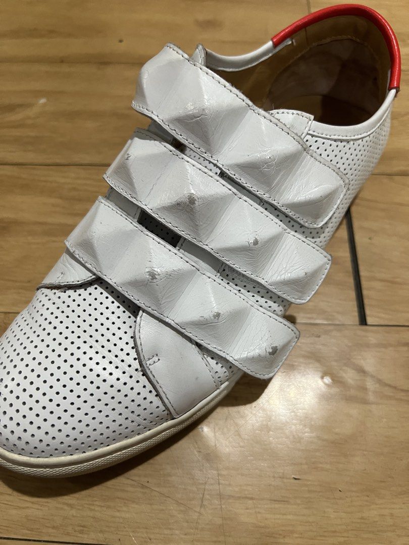 Givenchy White Velcro Sneakers with Red Heel Tab (Category: Sneakers) located in Pasig City. Submitted by shop.rdm (Listing ID 1468869507, Image 3). Description: - Brand: Givenchy - Style: White leather low-top sneakers with velcro strap closure - Details: Perforated upper, textured pyramid studs on straps, bright red heel counter with logo - Interior: Tan leather lining with gold foil branding - Inclusions: Original branded box included - Condit