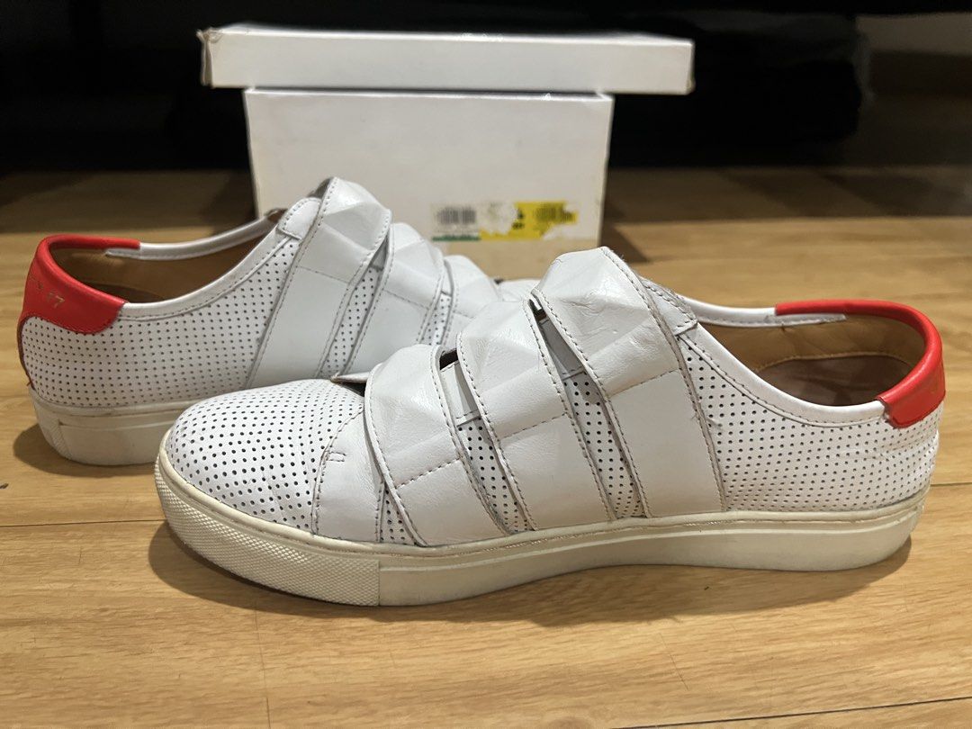Givenchy White Velcro Sneakers with Red Heel Tab (Category: Sneakers) located in Pasig City. Submitted by shop.rdm (Listing ID 1468869507, Image 1). Description: - Brand: Givenchy - Style: White leather low-top sneakers with velcro strap closure - Details: Perforated upper, textured pyramid studs on straps, bright red heel counter with logo - Interior: Tan leather lining with gold foil branding - Inclusions: Original branded box included - Condit