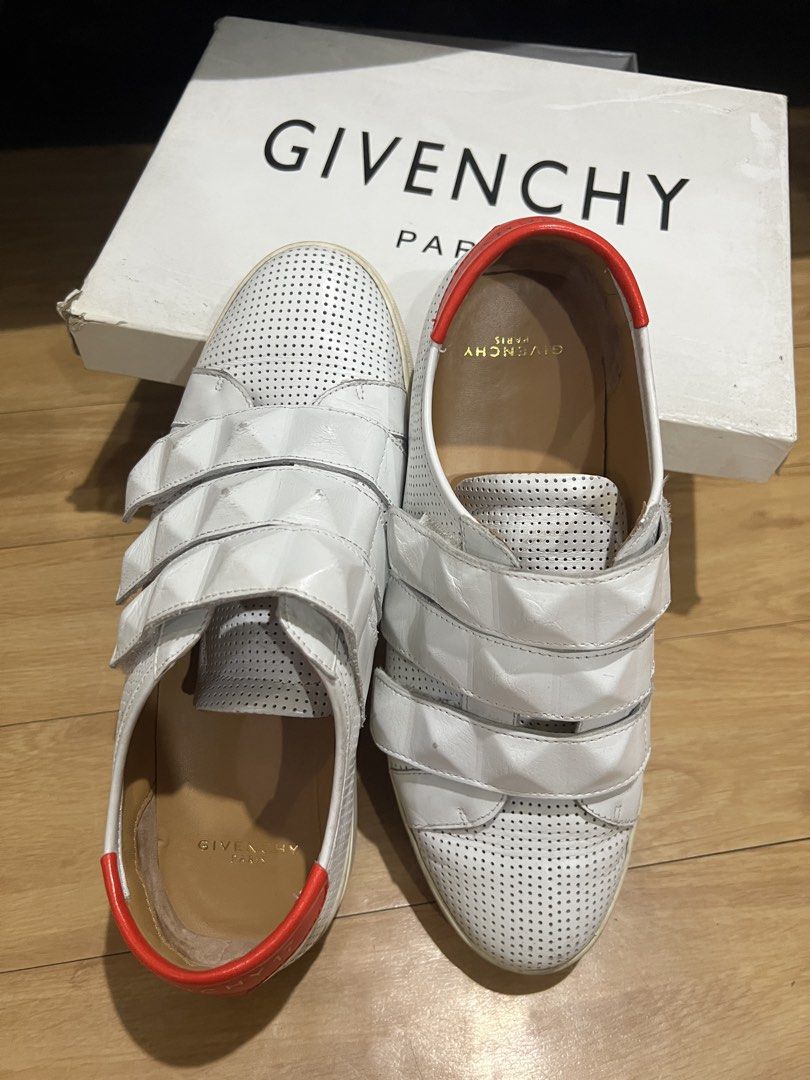 Givenchy White Velcro Sneakers with Red Heel Tab (Category: Sneakers) located in Pasig City. Submitted by shop.rdm (Listing ID 1468869507, Image 2). Description: - Brand: Givenchy - Style: White leather low-top sneakers with velcro strap closure - Details: Perforated upper, textured pyramid studs on straps, bright red heel counter with logo - Interior: Tan leather lining with gold foil branding - Inclusions: Original branded box included - Condit