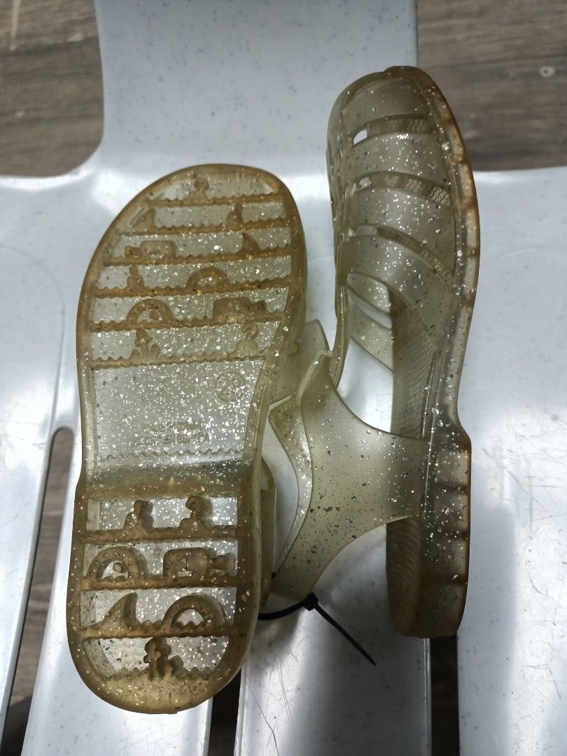 Glitter Jelly Sandals Size 28 (Category: Babies & Kids Fashion) located in Santa Maria. Submitted by anne_s.list (Listing ID 1468796248, Image 2). Description: - Color/Style: Clear gold with glitter, closed-toe woven design - Size: 28 (17.5 -18.5 cm) - Closure: Adjustable ankle strap with buckle - Sole: Textured with molded patterns for better grip - Origin: Made in Spain - Ideal for: Summer, beach trips, and everyday casual wear.