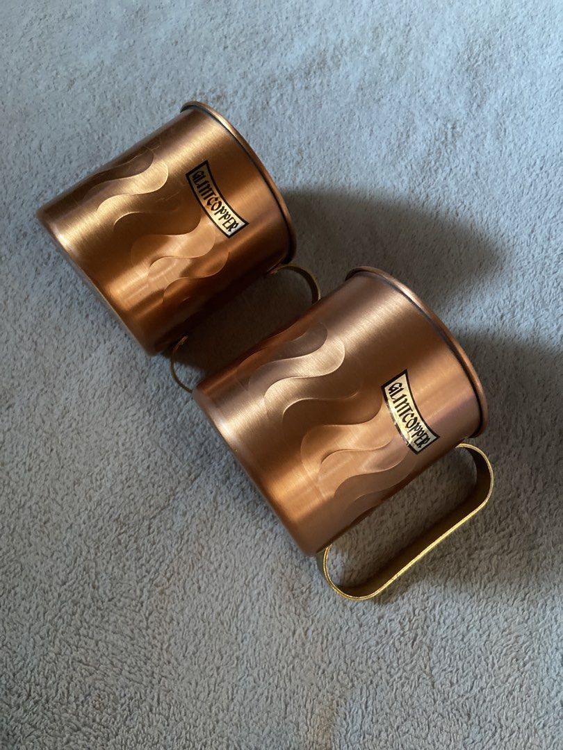 Glmitcopper Copper Mugs Set of Two (Category: Coffee & Tea Tableware) located in Davao. Submitted by mengsmixitems (Listing ID 1468713551, Image 1). Description: - Set of 2 authentic copper mugs - Features brass handles and a stylish wave-etched pattern - Silver-lined interior for safe and cool drinking - Stamped maker's mark on the bottom for authenticity - Ideal for serving Moscow Mules, cold beverages, or as a display piece.