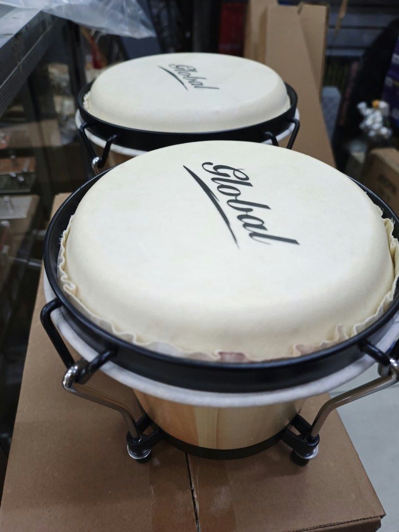 Global Wood Bongo Drums (Category: Musical Instruments) located in Las Pinas. Submitted by andreadomingo2518 (Listing ID 1468767125, Image 1). Description: - Product: Global bongo drums with dual drum setup connected by a wooden block - Finish: Natural wood finish with clean surfaces - Hardware: Black metal hardware, rims, and standard tuning lugs - Drum Heads: White drum heads featuring a clear brand logo - Condition: Ready to play.