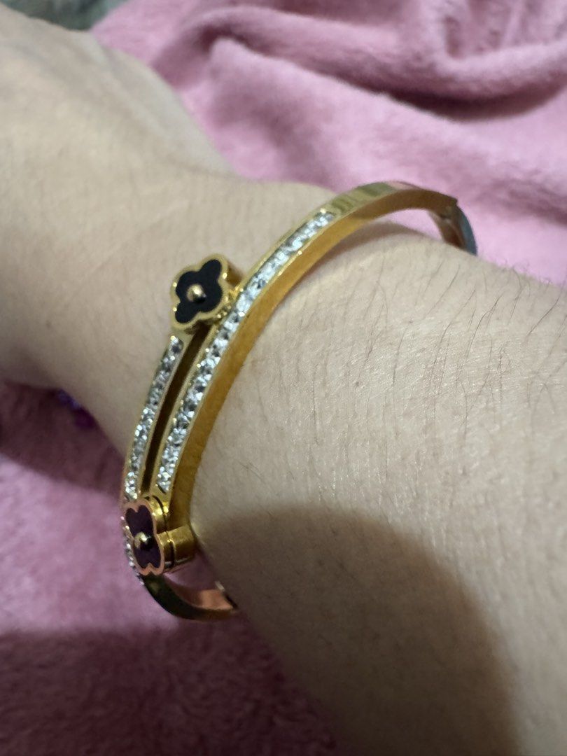 Gold Clover Bangle Bracelet with Rhinestones (Category: Bracelets) located in Angeles City. Submitted by thala.1204.68 (Listing ID 1468765715, Image 2). Description: - Gold-tone double band bangle bracelet - Features double rows of sparkly rhinestones - Elegant black clover charms with a small gold ball center at each end - Convenient hinged clasp closure on the side for easy wear - Versatile statement piece for daily use or dressing up.
