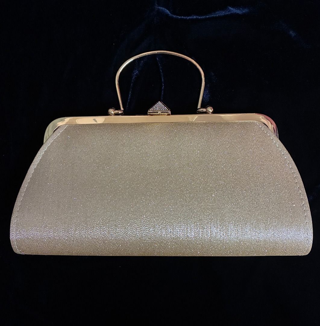 Gold Evening Bag | Clutch | Gold Tone Hardware (Category: Clutches) located in Quezon City. Submitted by maskedrecollections (Listing ID 1468913321, Image 1). Description: ✨ Gold glitter evening clutch with a structured frame and top handle. ✨ Rhinestone-encrusted pyramid clasp. ✨ Interior lined in dark fabric with a small slip pocket. ✨ Metal hardware in gold tone. ✨ Size: 9.5 inches at widest length at the bottom x 5 inches (see photo) ✨ Good f