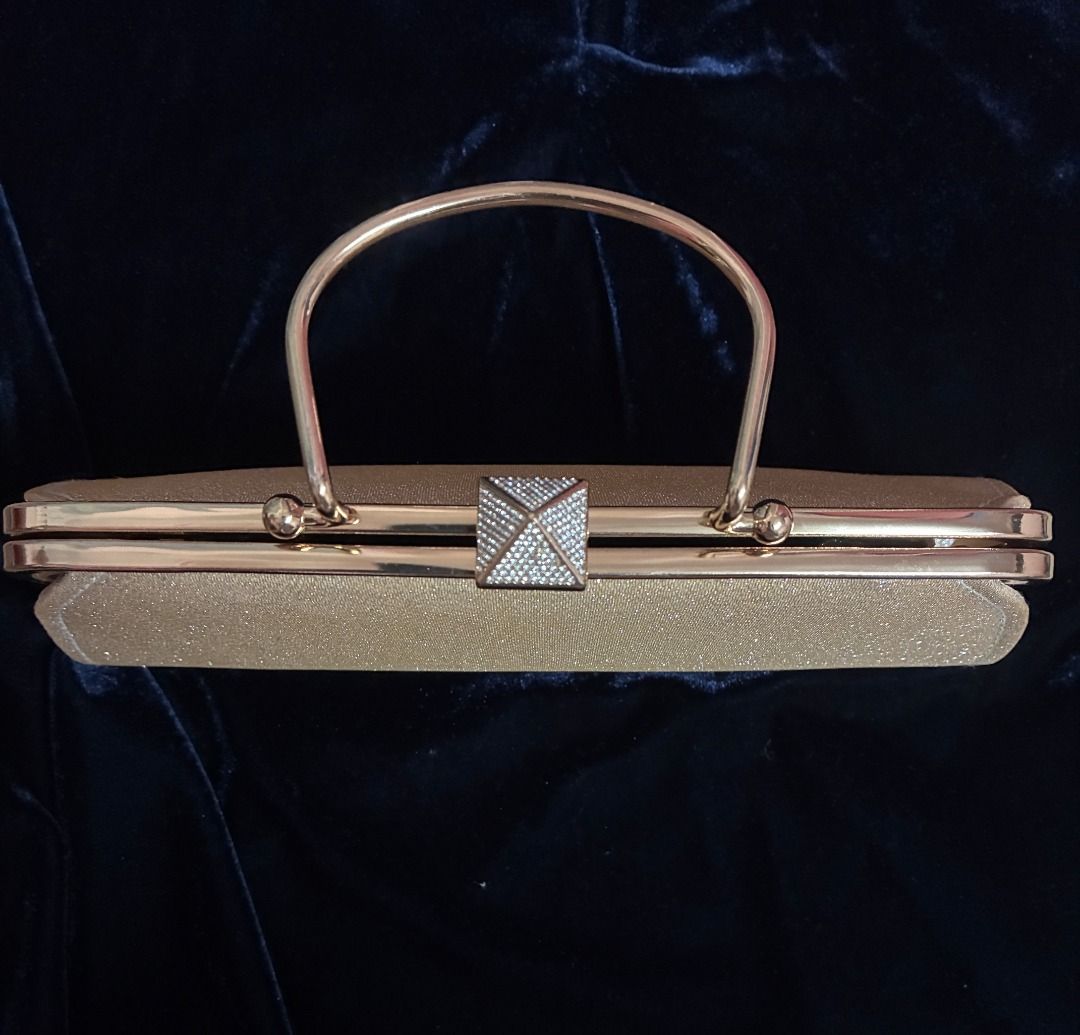 Gold Evening Bag | Clutch | Gold Tone Hardware (Category: Clutches) located in Quezon City. Submitted by maskedrecollections (Listing ID 1468913321, Image 3). Description: ✨ Gold glitter evening clutch with a structured frame and top handle. ✨ Rhinestone-encrusted pyramid clasp. ✨ Interior lined in dark fabric with a small slip pocket. ✨ Metal hardware in gold tone. ✨ Size: 9.5 inches at widest length at the bottom x 5 inches (see photo) ✨ Good f
