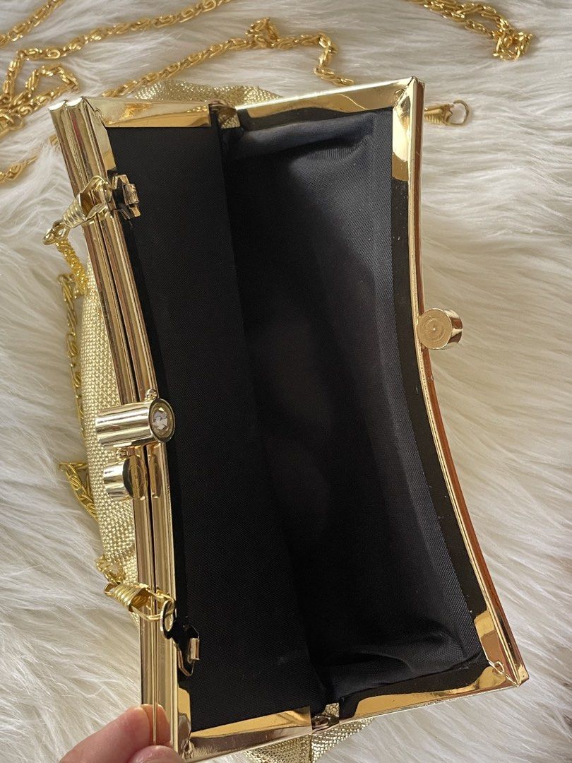 Gold evening clutch bag with chain strap (Category: Clutches) located in San Juan City. Submitted by redrosierose (Listing ID 1468715600, Image 3). Description: - Elegant textured gold clutch with secure gold-tone metal frame - Features a dazzling rhinestone clasp closure on top - Comes with a detachable gold chain strap for shoulder or crossbody wear - Spacious main compartment lined with sleek black fabric - Ideal accessory for weddings, partie