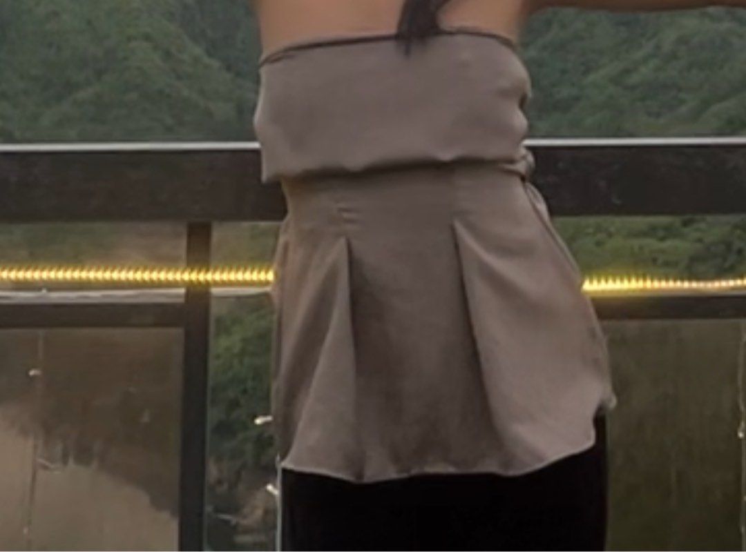 Gray Strapless Pleated Peplum Tube Top (Category: Sleeveless) located in Manila. Submitted by julieeeewwwww (Listing ID 1468844049, Image 2). Description: - Color: Versatile taupe neutral shade - Size: XS-Fitted Med - Design: Strapless with a structured sweetheart bodice and pleated peplum flare at the waist - Fit: Stretchy smocked back panel for a snug and secure fit - Styling: Easily dressed up with trousers or kept casual with jeans - Conditio