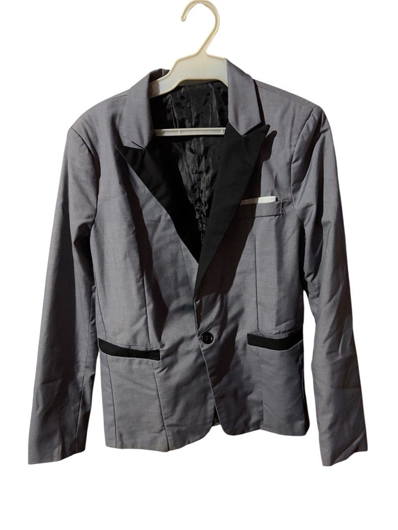 Grey Blazer with Black Lapels (Category: Coats, Jackets and Outerwear) located in Antipolo. Submitted by joyeduarte175 (Listing ID 1468767929, Image 1). Description: - Color: Grey with contrasting black lapels and pocket trims - Closure: Single button front - Pockets: Single welt chest pocket with white pocket square accent - Details: Structured shoulders, decorative cuff buttons - Lining: Fully lined in black interior - Condition: Excellent / Re