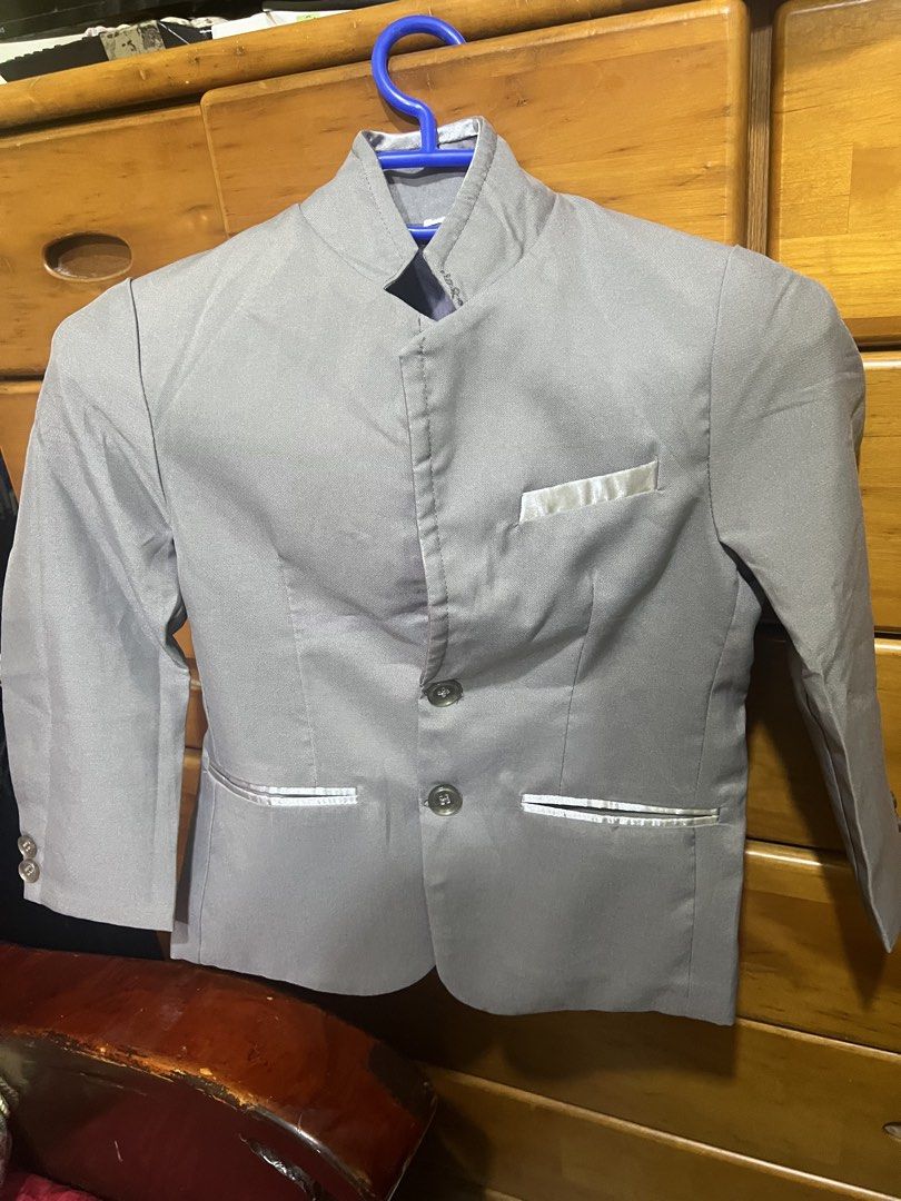 Grey Boys Mandarin Collar Suit Jacket (Category: Coats, Jackets and Outerwear) located in Carmona. Submitted by tonette95 (Listing ID 1468777780, Image 1). Description: - Color: Grey - Style: Mandarin collar with two-button closure - Pockets: One chest pocket and two lower pockets with shiny silver trim - Details: Cuff buttons on sleeves, structured shoulders, and tailored fit - Condition: Clean fabric throughout Ginamit lang ng kasal. Isang bese